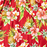 Red smocked top dress with spaghetti straps and designed with pineapples, hibiscus and green leaves print close up.