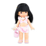 Doll wearing floral-print bathing suit and holding a small pink bag