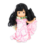 Doll wearing bright pink dress and lei