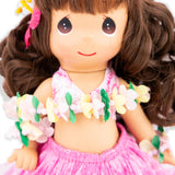 Close up on the face of the doll wearing a floral lei