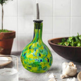 Blown Glass Yellow & Green Cruet with salad bowl, garlic cloves on a kitchen counter