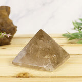 Small Quartz Pyramid on a desk displaying the roundness and the point at the top